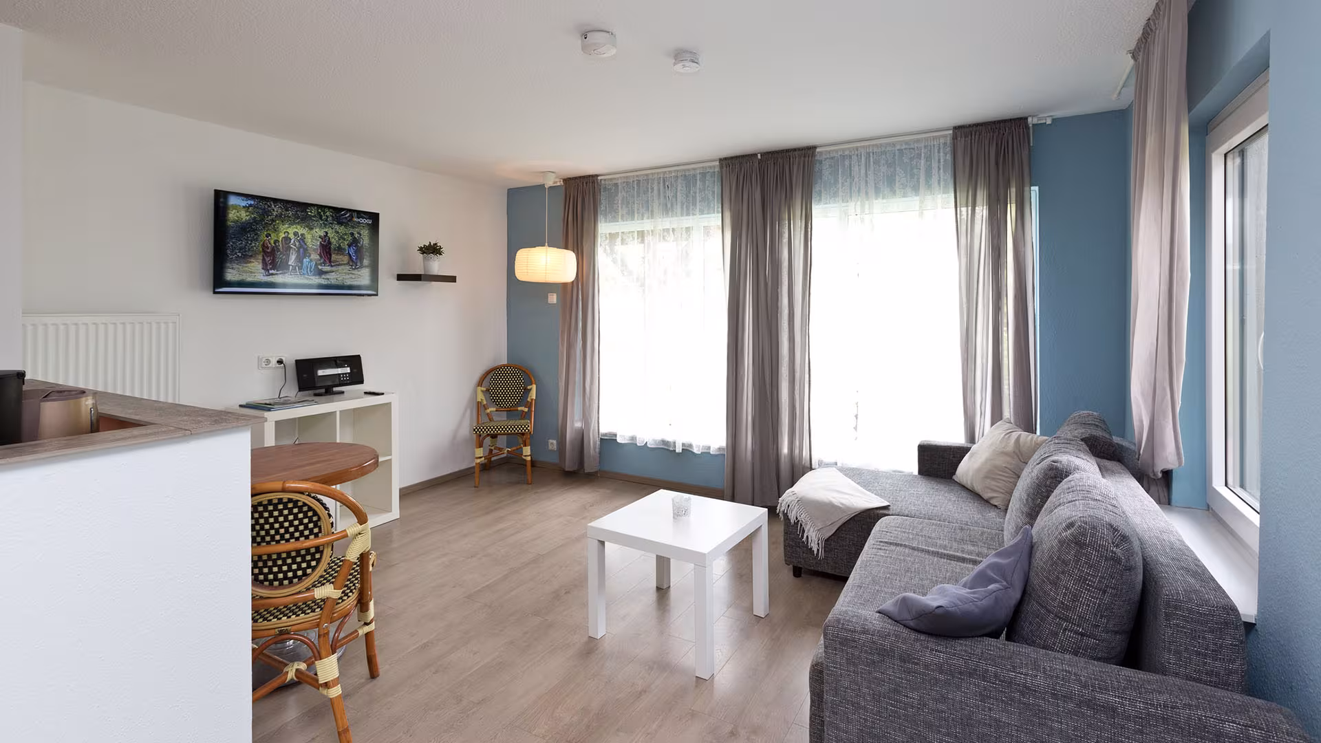 Wohnbereich mit Sofa und Küchenzeile in der Ferienwohnung an der Müritz in Jabel