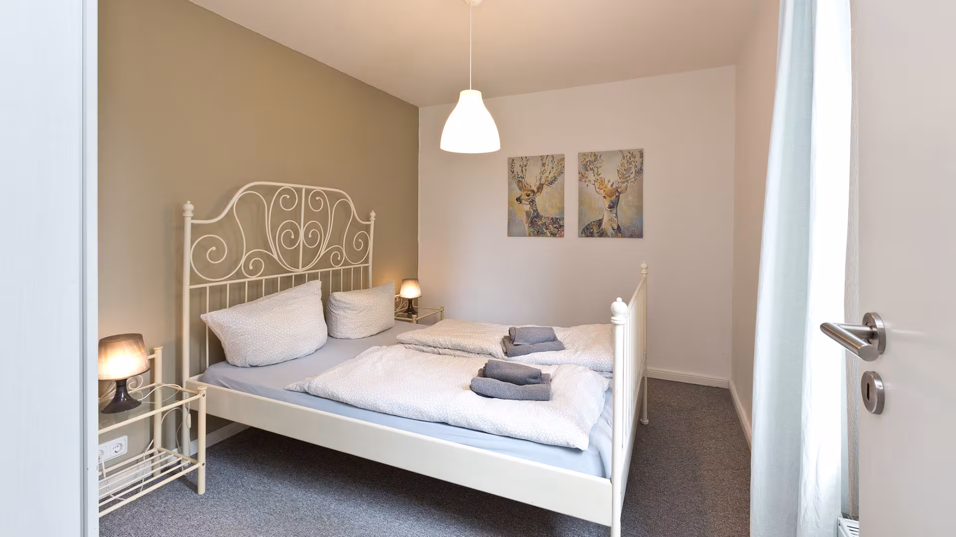 Schlafzimmer mit Doppelbett und Wandbildern in der Ferienwohnung an der Müritz in Jabel