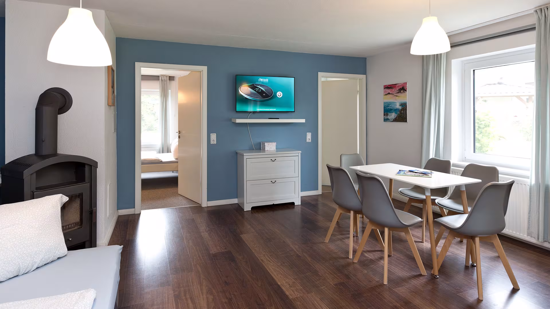 Wohn- und Essbereich mit Kaminofen und TV in der Ferienwohnung an der Müritz in Jabel