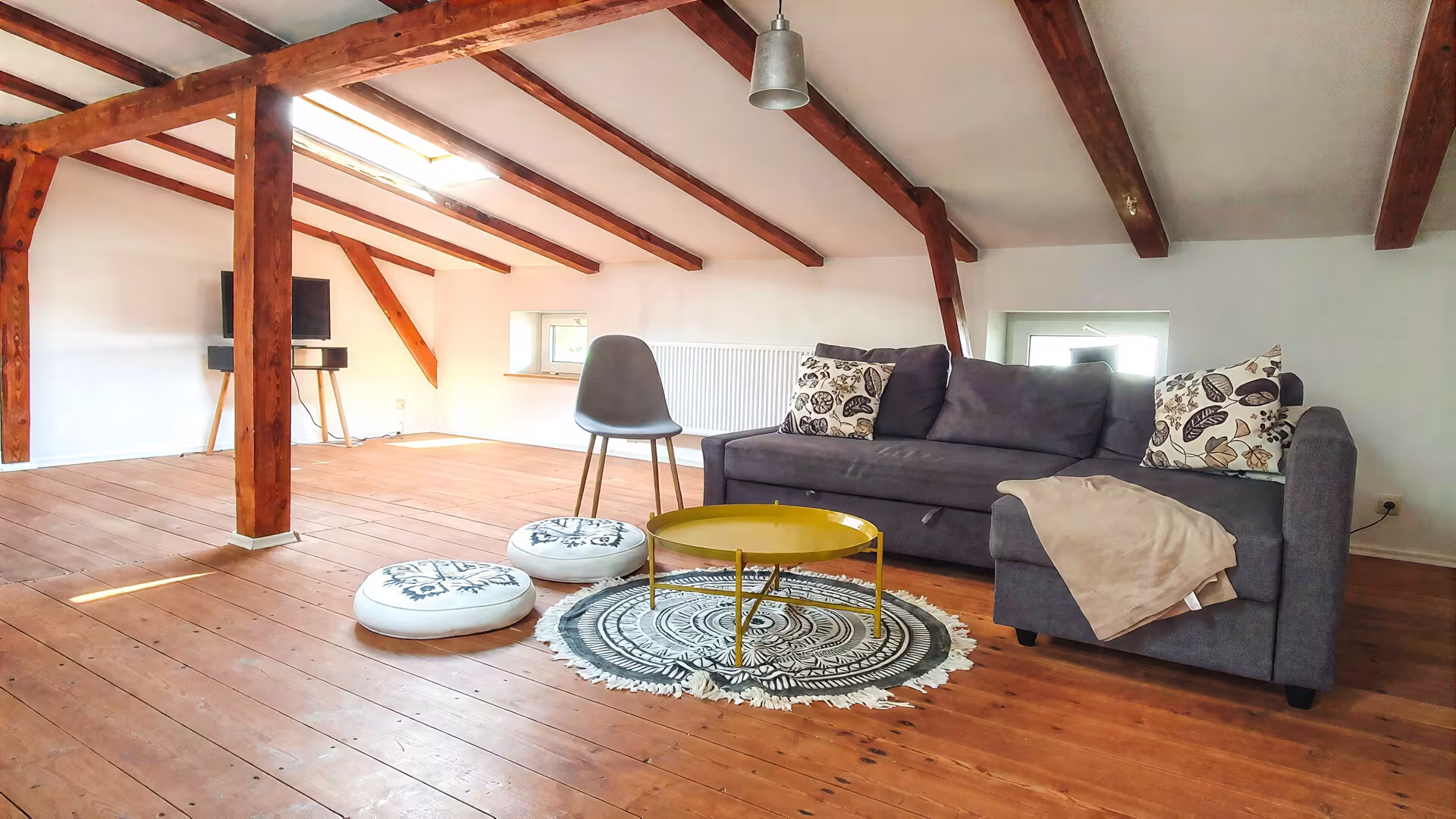 Wohnzimmer mit Sofa und Dachbalken im Ferienhaus an der Müritz in Jabel