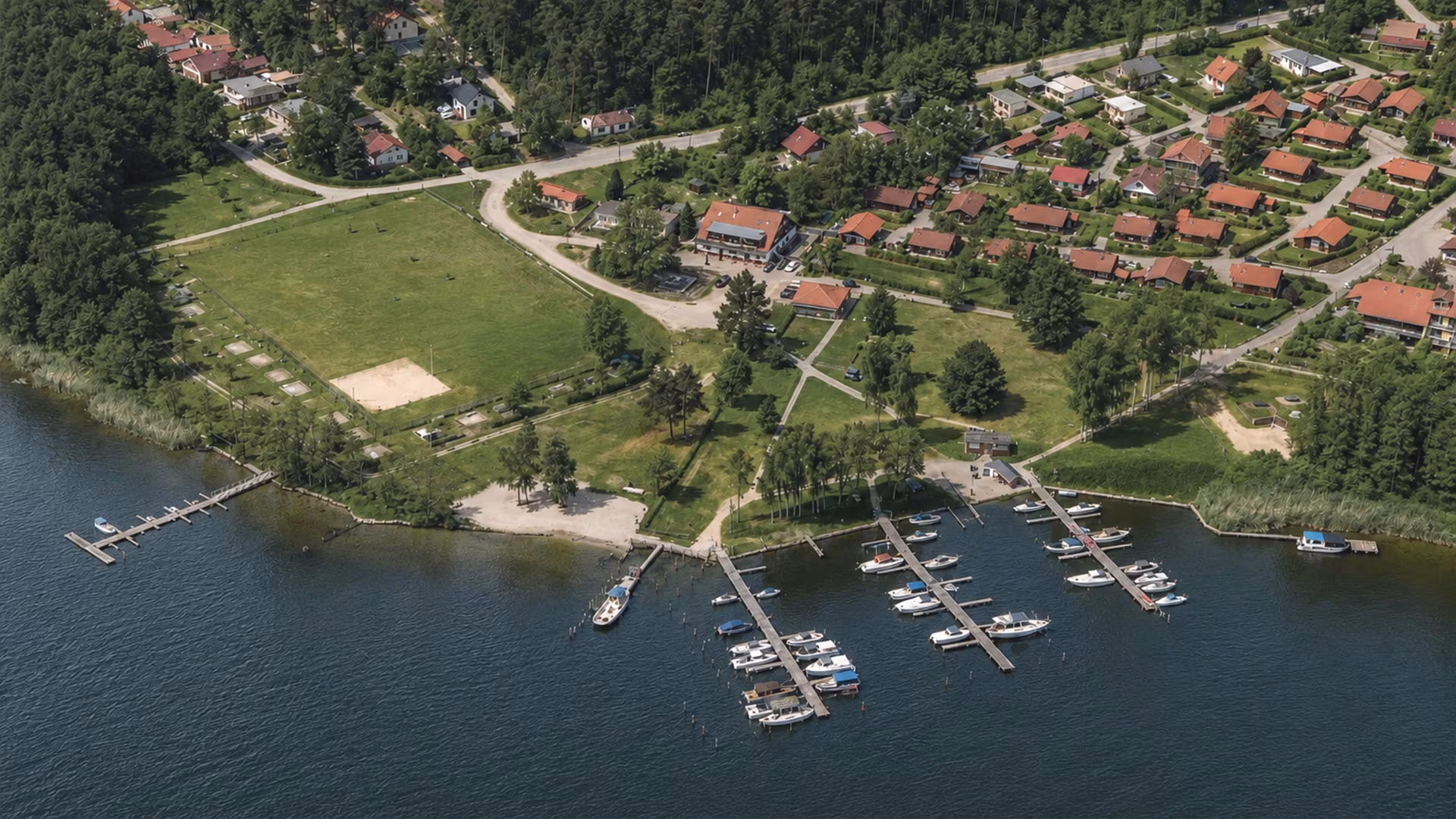 Luftbild einer kleinen Stadt an der Müritz mit Hafen und Grünanlage