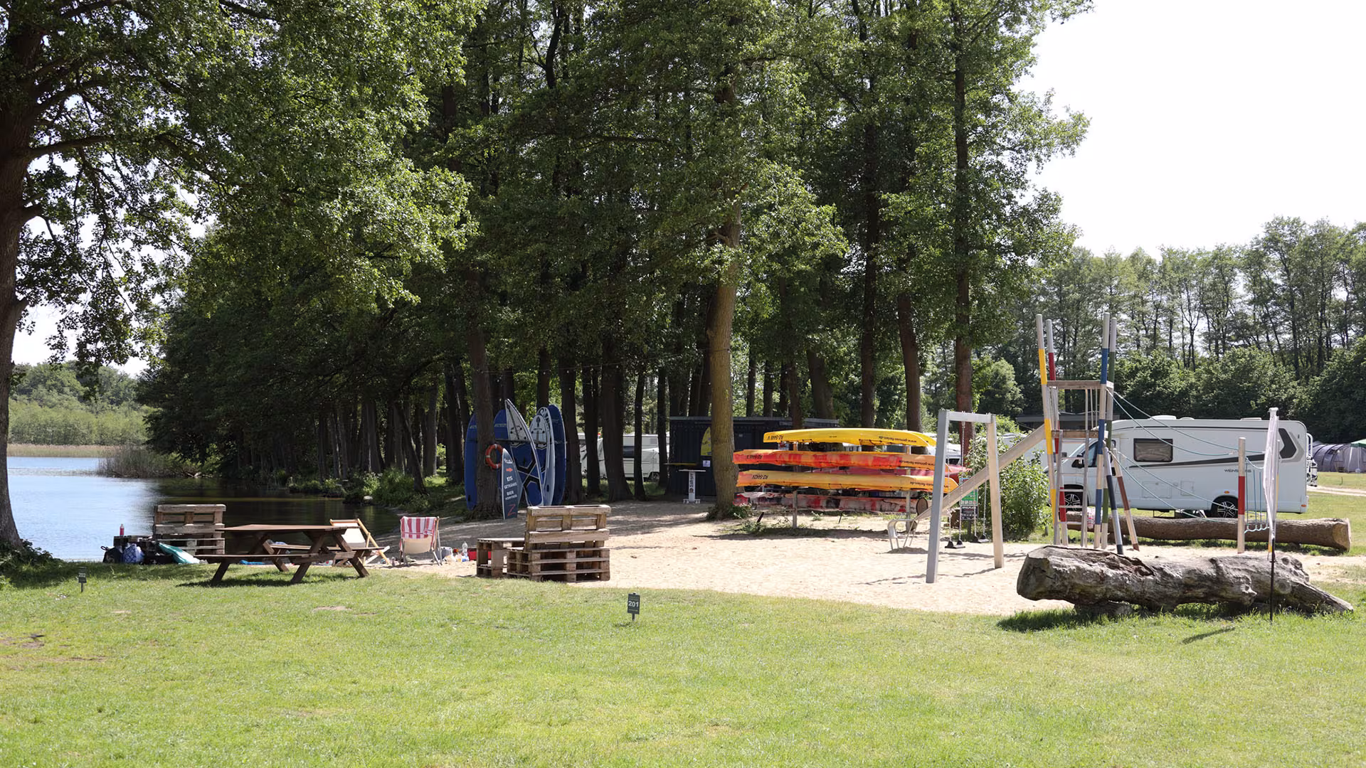 Wiese mit Picknick- und Spielbereich am Waldrand des Campingplatzes
