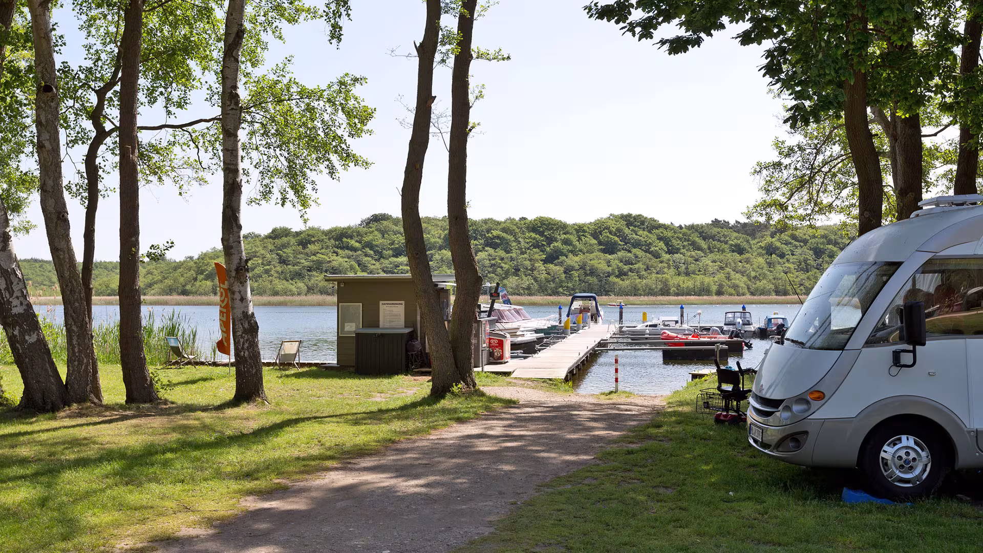 Wohnmobil am Wasser mit Bootssteg und Booten