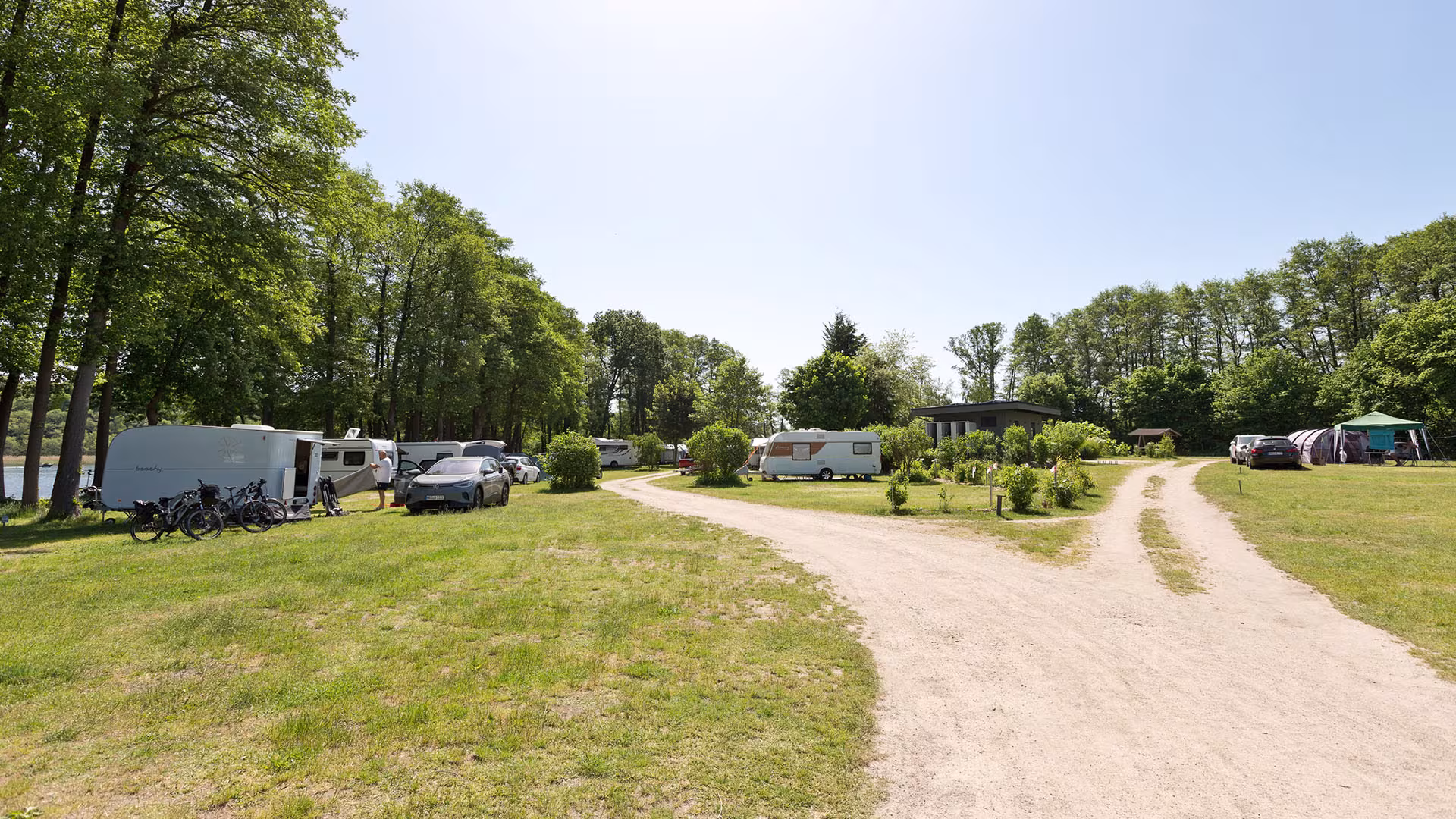 Weg durch den Naturcampingplatz mit Wohnwagen und Bäumen