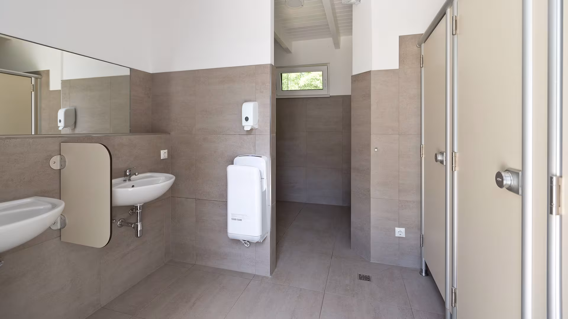 Barrierefreier Waschraum mit Waschbecken und Spiegel
