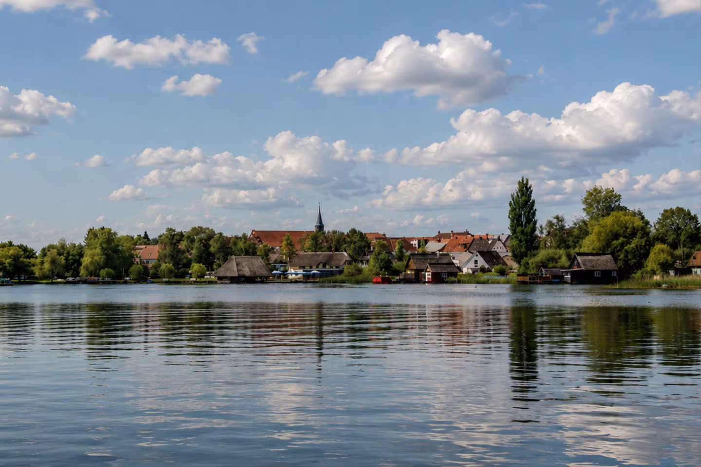 Blick über den Jabelschen See auf ein Dorf an der Müritz